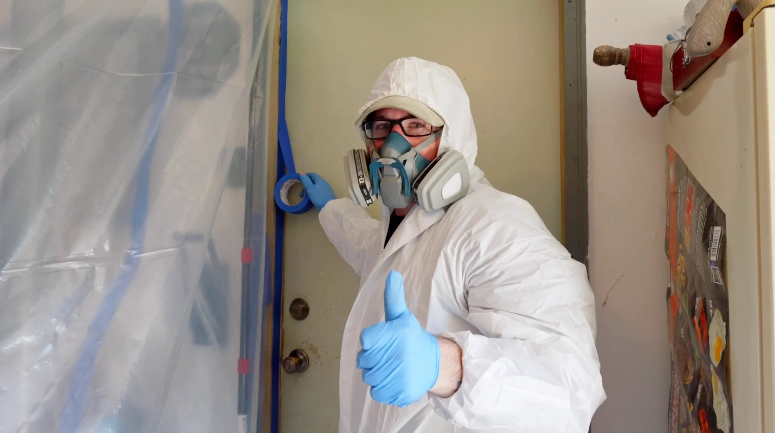 Certified mold remediation tech in Andover Township NJ wearing full PPE Thumbs Up in Front of Containment area.